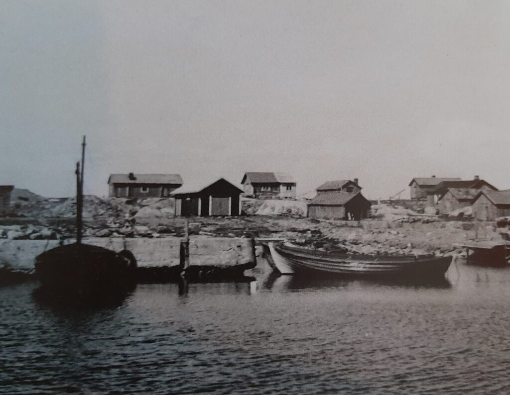 Gammal svartvit bild på en liten hamn.