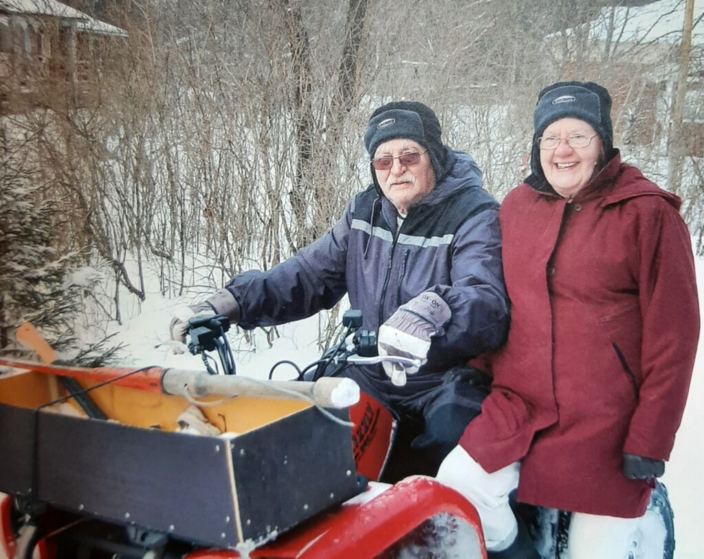 En äldre kvinna och en man på fyrhjuligt motorfordon på vintern.