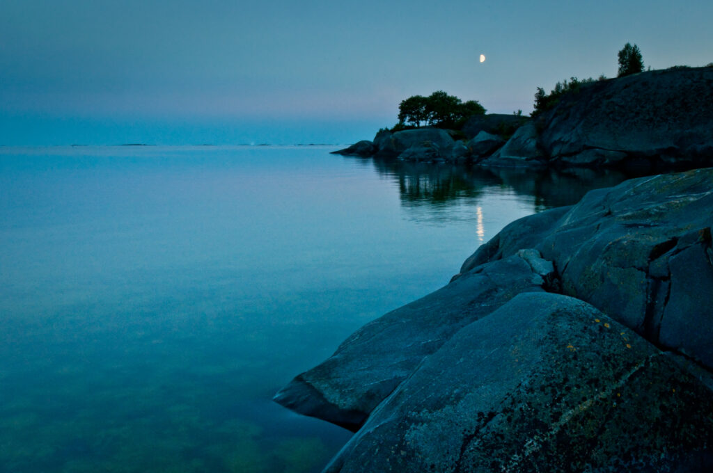 Klippig kust i månsken.