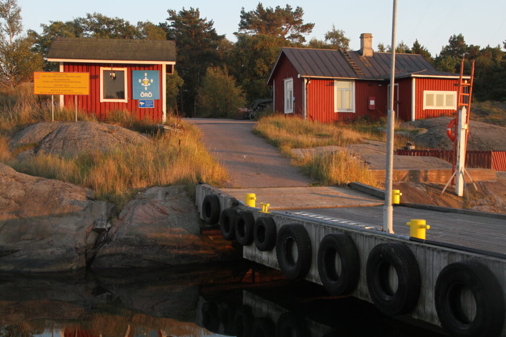 Två röda hus och en brygga.